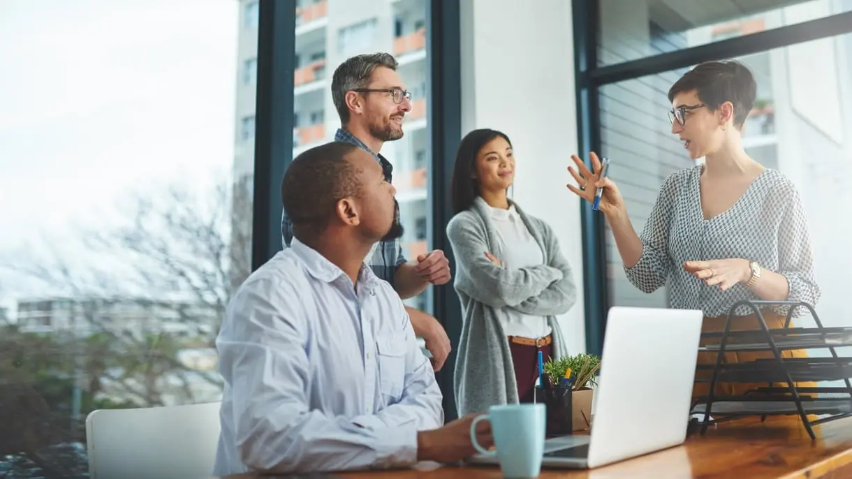 Four professionals doing API banking at a computer