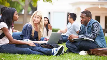  Group of students with an open laptop having a discussion