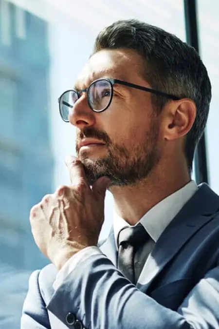 Man in suit wearing glasses and gazing into the sky