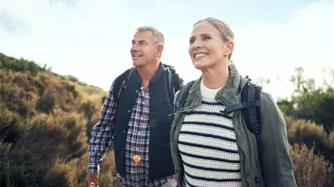 Senior couple hiking with backpacks