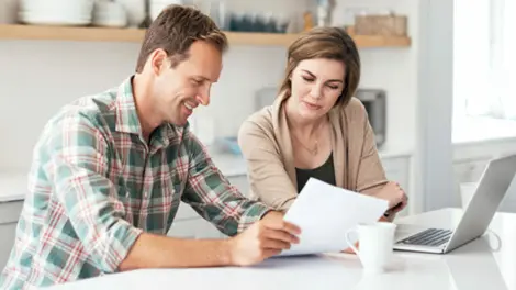 young couple loos at portfolio over kitchen island