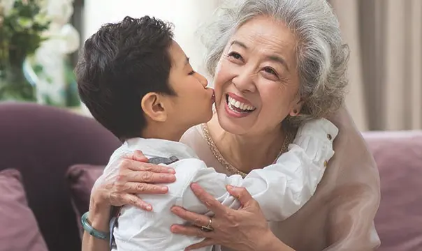 Grandson kisses his grandmother on the cheek