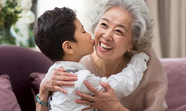 grandson hugging grandmother and giving her a kiss on the cheek