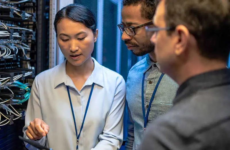 Three colleagues standing and discussing cybersecurity at work