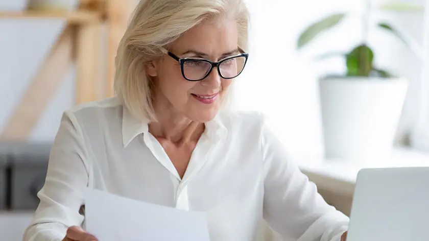 Older professional woman analyzing payments on a laptop